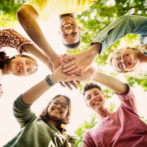 A diverse group of teens stacking hands in a circle