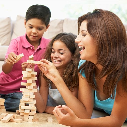A mother playing a stacking game with her two children